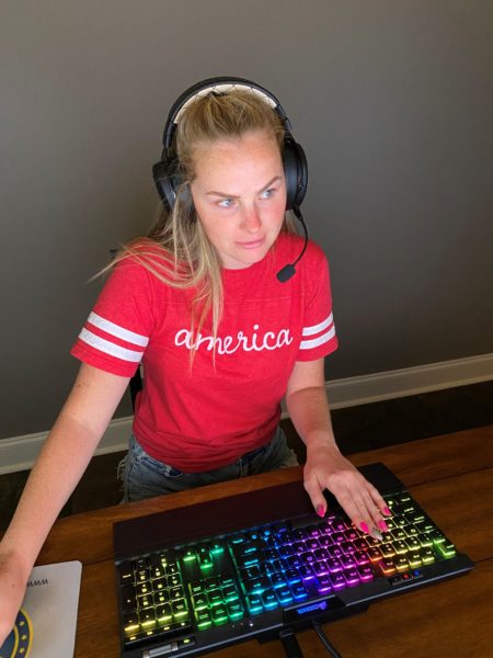 Courtney working on her computer, wearing headphones